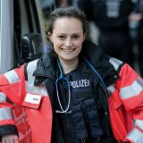 Ein blaues Stethoskop baumelt über der Polizeiweste: Die Aufgaben draußen vor Ort sind oft gefährlicher als der Klinikalltag.