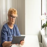 Symbolbild: Eine Frau hält einen Tablet-Computer in der Hand.