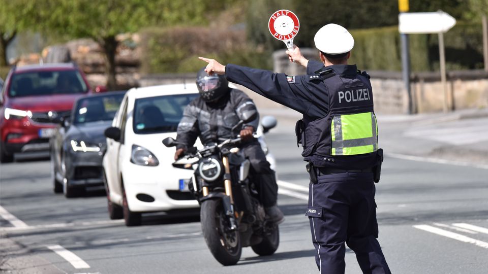 Polizeibeamter hält einen Motorradfahrer an