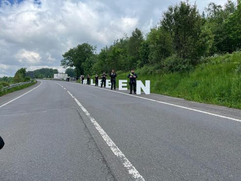 Der Schriftzug #LEBEN am Rand einer Straße, dazwischen stehen Polizeibeamte. 