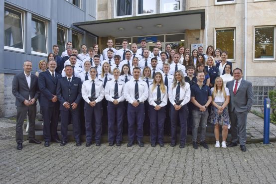 Gruppenbild vor der Poliizeiwache Iserlohn mit jungen Polizeibeamten in weißen Hemden.