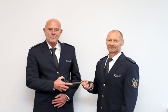 Volker Mürmann (links) übergibt Thorsten Ausborn (rechts) symbolisch den Schlüssel der Polizeiwache Lüdenscheid