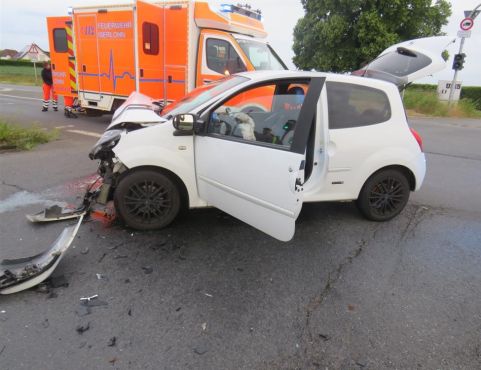 Ein weißer, vorne kaputter Unfallwagen vor einem Rettungswagen
