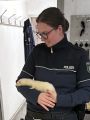 Eine Polizeibeamtin mit einem Frettchen auf dem Arm.