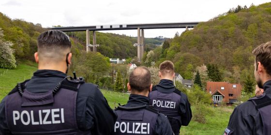Polizeibeamte beobachten die Sprengung der Rahmedetalbrücke in Lüdenscheid